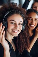 Group of young women enjoying music together in a lively indoor setting during the day photo
