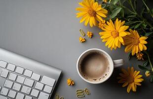 Cozy workspace with coffee and vibrant yellow flowers on a gray table photo