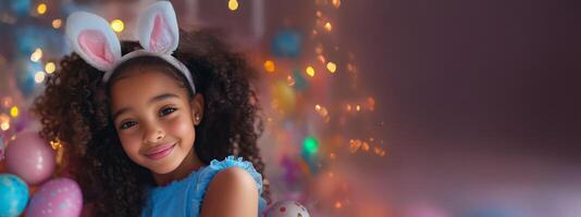 Little girl with curly hair and bunny ears smiling in colorful setting during festive celebration photo