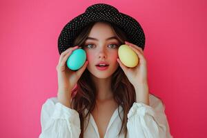 Young woman holding colorful eggs in front of pink background during spring celebration photo