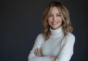 Smiling woman with wavy hair wearing a cozy sweater against a dark background photo