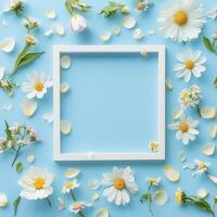 Bright spring flowers arranged around a white frame on a blue background create a cheerful atmosphere photo