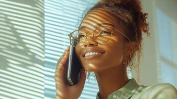 Young woman smiling while talking on phone in bright room with striped shadows photo
