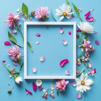 Colorful flower arrangement with empty frame on blue background for creative display photo