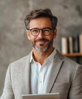Professional man in modern office with tablet and warm smile during a workday photo