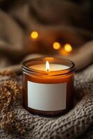 Serenity and warmth at home with a lit candle on cozy knitted fabric and soft glow of background lights photo