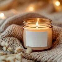 Relaxing candle burns softly on cozy knit blanket with warm lights in background during evening photo