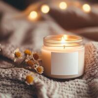 Cozy candle on knitted blanket with flowers and warm lights in peaceful indoor setting photo