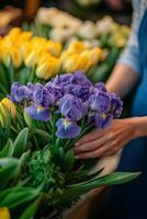 Flower vendor arranging vibrant blooms of irises and tulips in a colorful market setting photo
