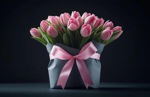 Beautiful pink tulips arranged in a decorative bouquet with a ribbon on a dark background photo