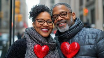 Couple celebrating love in a city street during winter with heart decorations photo