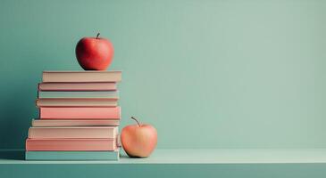 Books stacked with red apples on a pastel blue background in a cozy study setup photo