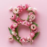 Floral arrangement forms the number eight on a soft pink background photo