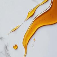 Golden syrup flowing on a white marble surface creates a visually appealing contrast photo