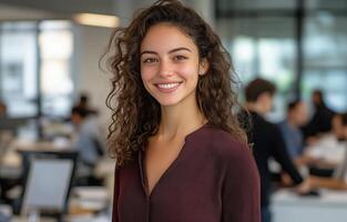 Professional woman with curly hair smiling in a modern office environment during work hours photo