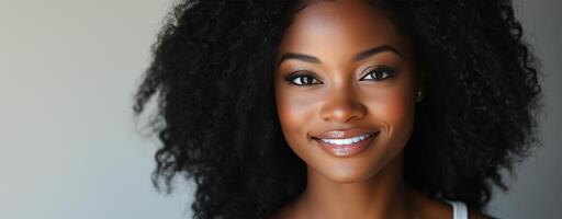 Woman with curly hair smiles brightly in a natural light setting photo