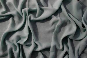 wavy crumpled abstract background texture Nude green fabric with copy space. photo
