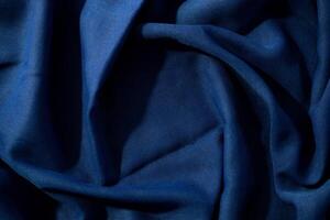 wavy spiral crumpled background texture Navy or dark blue fabric with copy space in the center. photo