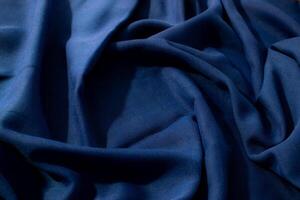 wavy spiral crumpled Navy or dark blue fabric background texture with copy space in the center. photo