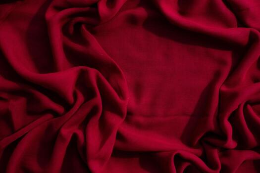 Red fabric wavy crumpled background abstract texture with copy space. photo