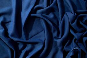 abstract background texture Navy or dark blue fabric wavy spiral crumpled with copy space in the center. photo