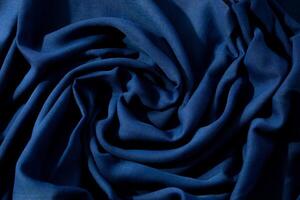 Navy or dark blue fabric wavy spiral crumpled background texture. photo