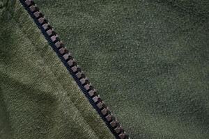 Zipper on Green army jacket fabric texture background. photo