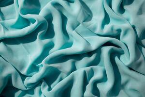 Turquoise wavy crumpled fabric with little sparkling dust, fabric texture and background. photo