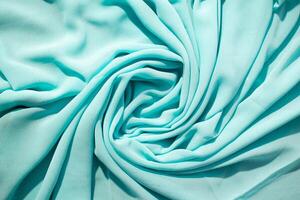 Spiral Twisted Turquoise wavy crumpled fabric with little sparkling dust photo