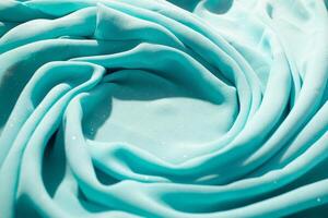 Spiral Twisted Turquoise with little sparkling dust wavy crumpled fabric and copy space in center, texture and background. photo
