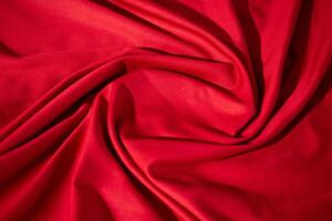 Red fabric wavy spiral crumpled fabric texture with copy space. photo
