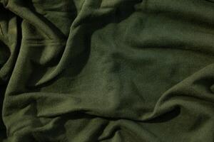 Green army fabric wavy crumpled anstract background texture. photo