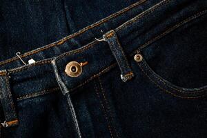 Close up gold and shiny button navy blue jeans fabric abstract background texture. photo