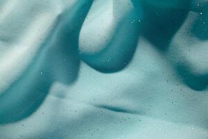 Close up Turquoise wavy crumpled fabric with little sparkling dust, texture and background. photo