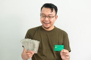 Happy asian man hold credit card and money. Banking, Financial isolated background, green color concept. photo