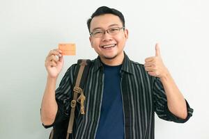 Smile Asian Student hold credit card and doing Ok sign gesture. School, Banking, Financial isolated background, blue concept. photo
