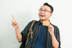 Joyful asian student hold credit card with pointing gesture. Banking, Financial isolated concept. photo