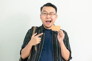 Smiling asian student hold and pointing credit card gesture. Banking, Financial isolated concept. photo