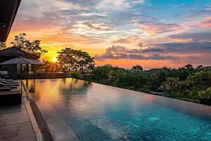 Swimming pool in luxury hotel resort with sunset sky and cloud background photo