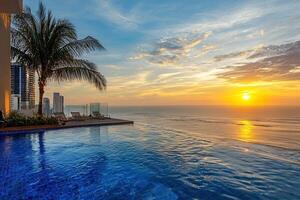 Beautiful sunset above swimming pool in luxury hotel resort with palm tree photo