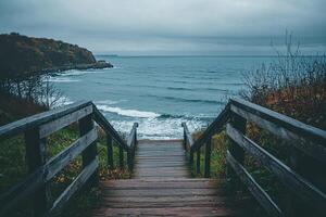 Wooden stairs leading to the sea on a cloudy autumn day photo
