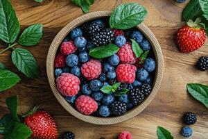Fresh berries in a bowl on a wooden background. Top view photo