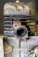 Close-up of rusty exhaust port on vintage motorcycle engine cylinder showing signs of wear and tear photo