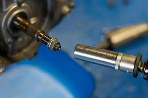 Mechanic using socket wrench installing bolt into engine part photo