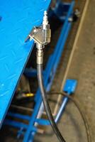 Pneumatic hose coupling connecting to a blue metal structure photo