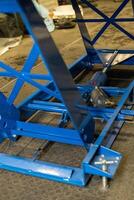 Blue hydraulic scissor lift table showing its lifting mechanism photo