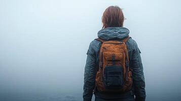 A lone adventurer stands against the fog, reflecting on the journey ahead photo