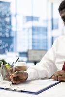 Man signing contract after being vetted by HR employee ensuring skills match role needs. Person filling application form after headhunter assessed his previous work experience photo