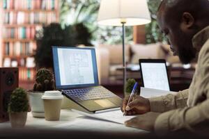 Professional businessman examining architectural sketches and blueprints to create a new startup office space. Focusing on strategic planning and layout design measurements. Business development. photo