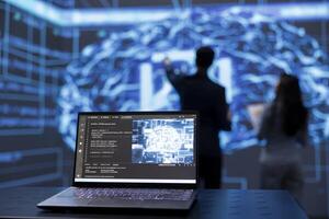 Focus on laptop used by engineers in blurry background to use AI cognitive computing. Close up shot of notebook used by IT professionals to run artificial intelligence technology on notebook photo